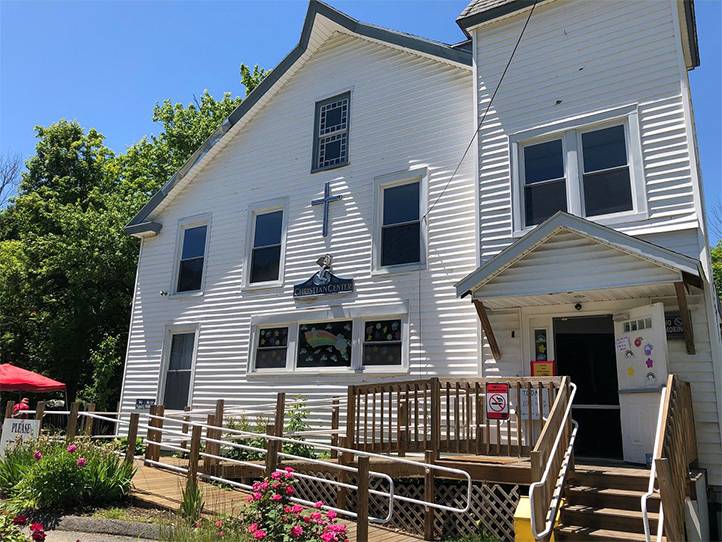 White clapboard church with wooden ramp