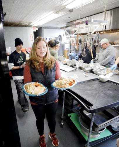 Volunteer carrying two plates of food
